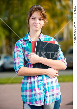 Portrait of young alluring woman holding education books. Student girl. 19126675