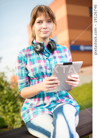 Beautiful young woman student with note pad. Outdoor student. 19126746