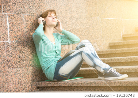 Beautiful young woman student with headphones. Outdoor music girl 19126748