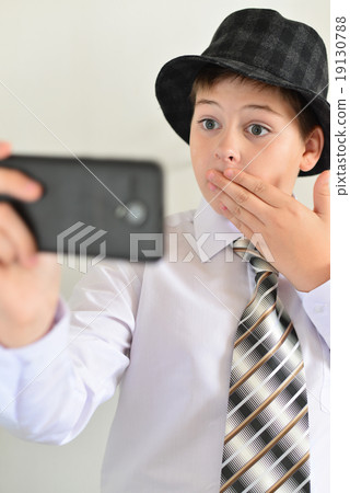 Teen boy with surprise looks at  mobile phone 19130788