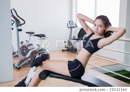 young fit woman sit up in fitness room young fit woman sit up in fitness room 19131164
