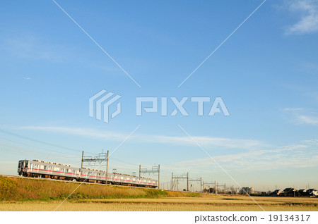 Tobu train running along the embankment following the Tone River with the blue sky back 19134317
