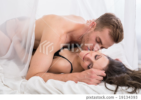 Young lovers lie in the bed. 19134393