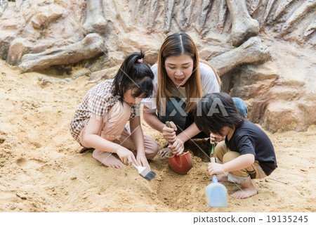 Asian family has fun digging in the sand 19135245