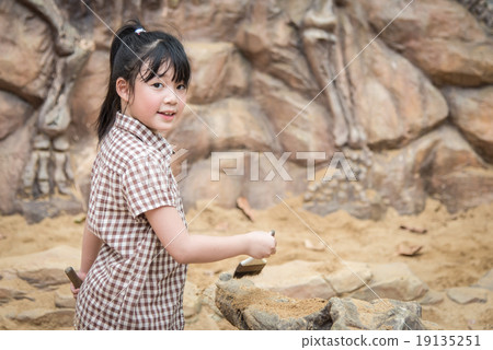 Little asian girl have fun digging in the sand Little asian girl have fun digging in the sand 19135251