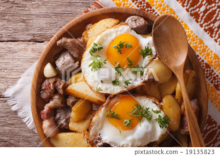 fried potatoes with meat and eggs closeup in bowl fried potatoes with meat and eggs closeup in bowl 19135823