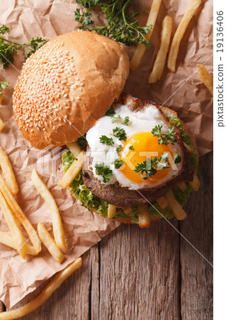 sandwich with grilled meat, a fried egg and fries 19136406