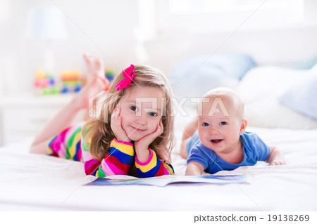 Stock Photo: Kids reading in white bedroom