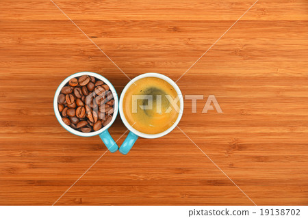 Two coffee cups espresso and beans over wood Two coffee cups espresso and beans over wood 19138702