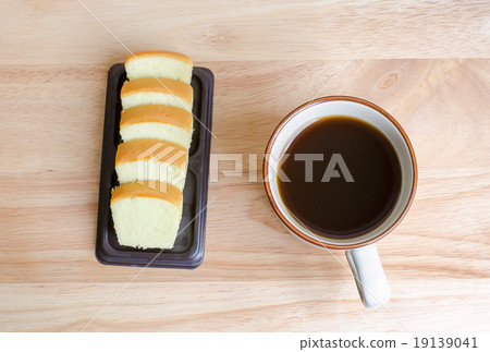 Coffee and slice of butter cake on wooden table 19139041