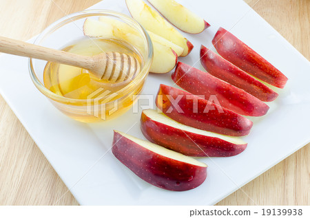 Apple with honey in plate on wooden table 19139938