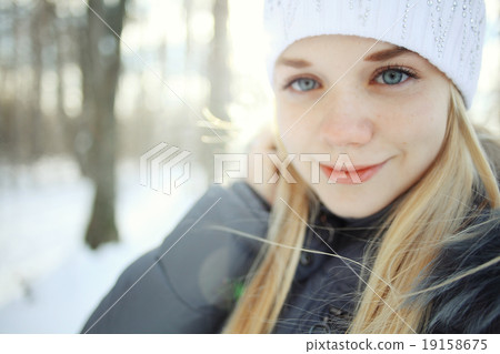 portrait of a young blonde girl in winter forest in the park 19158675