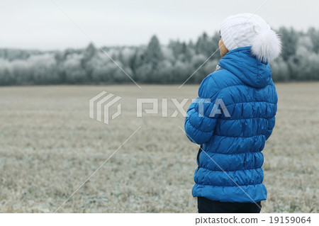 girl in a blue down jacket winter view from the back 19159064