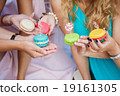 colorful macaroons in the hands of the girls white 19161305