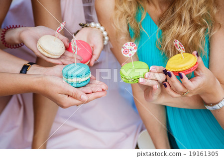 colorful macaroons in the hands of the girls white colorful macaroons in the hands of the girls white 19161305