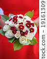 wedding bouquet in hands of the bride on a red  19161309