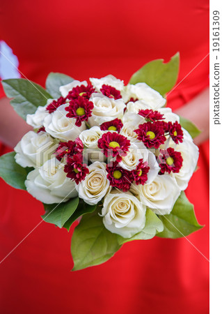 wedding bouquet in hands of the bride on a red  wedding bouquet in hands of the bride on a red  19161309