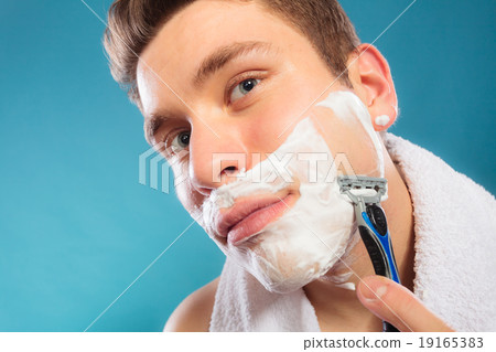 Young man shaving using razor with cream foam. Young man shaving using razor with cream foam. 19165383