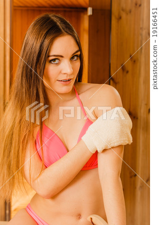Woman in sauna with exfoliating glove. Skincare. Woman in sauna with exfoliating glove. Skincare. 19166451