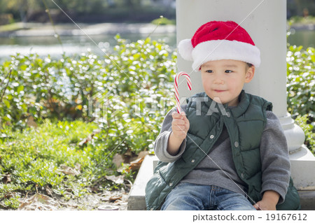 Cute Mixed Race Boy With Santa Hat and Candy Cane 19167612