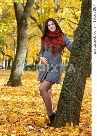 girl portrait with red scarf in autumn city park, fall season 19168867