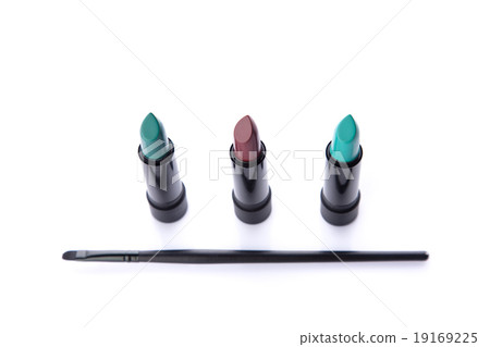Top view of makeup brush and three lipsticks 19169225