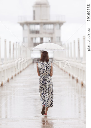 woman and umbrella walking on jett bridge 19169388