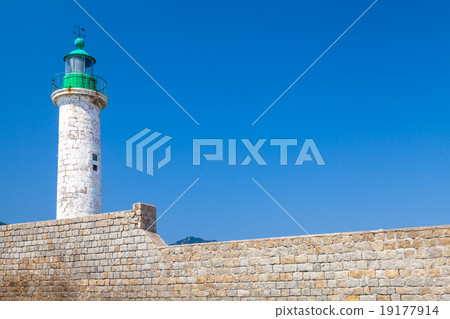 White lighthouse tower on stone pier 19177914