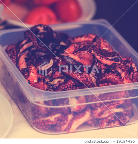 Cooked octopus parts in a box 19184450