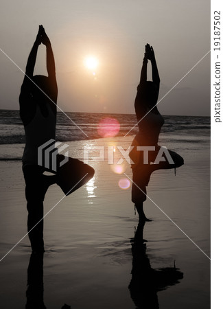 Serene People In The Beach Doing Yoga In The Sunset Concept Serene People In The Beach Doing Yoga In The Sunset Concept 19187502