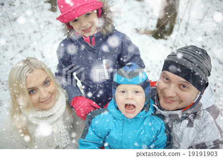 Family Christmas walk in a snowy park 19191903