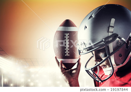 Composite image of sportsman looking down while holding american 19197844