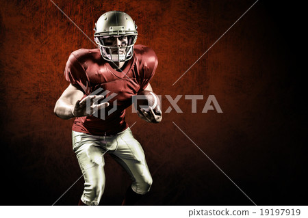 Composite image of portrait of defensive sportsman holding ameri Composite image of portrait of defensive sportsman holding ameri 19197919