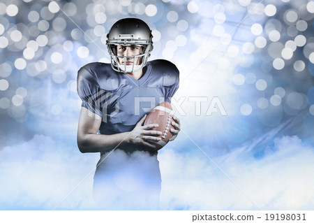 Composite image of confident american football player holding ba 19198031