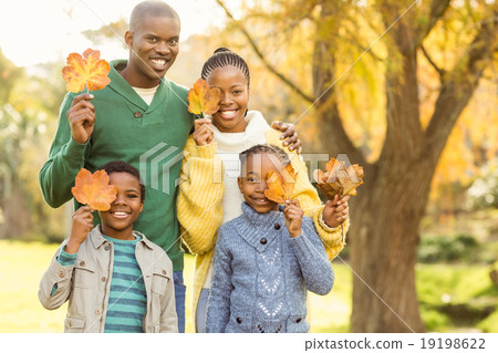 Portrait of a young smiling family holding leaves 19198622