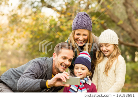 Smiling young family taking selfies 19198691