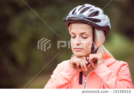 Woman fastening her bike helmet 19198818