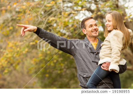 Father showing something to his smiling daughter 19198955