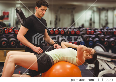 Fit woman working out with trainer 19199023