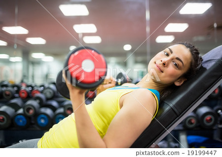Smiling woman doing a workout with dumbbells Smiling woman doing a workout with dumbbells 19199447