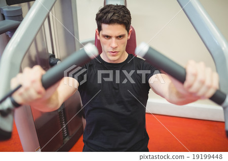 Fit man using weights machine for arms Fit man using weights machine for arms 19199448