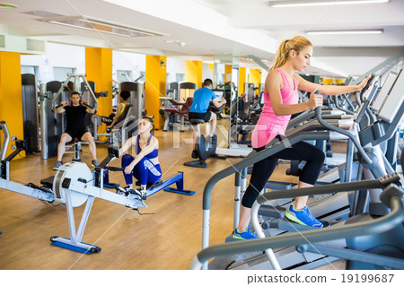 Fit people working out using machines 19199687