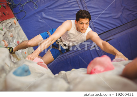 Man climbing up rock wall 19200431