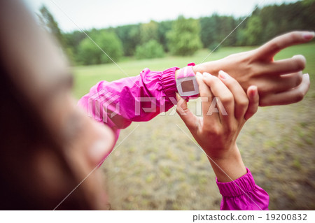 Woman using her smartwatch on a hike Woman using her smartwatch on a hike 19200832