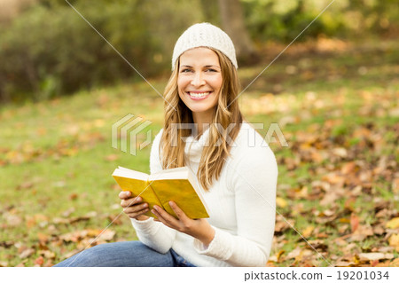 Portrait of a smiling pretty woman reading a book Portrait of a smiling pretty woman reading a book 19201034