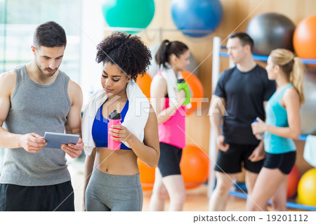 Client and trainer looking at tablet pc 19201112