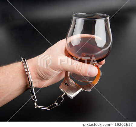 A hand locked to glass of alcohol A hand locked to glass of alcohol 19201637