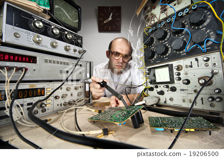 Funny nerd scientist soldering at vintage laboratory 19206500