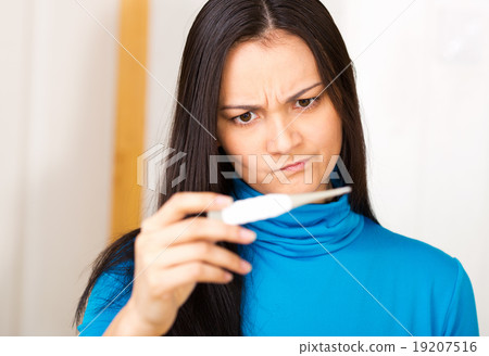 Women looking at thermometer Women looking at thermometer 19207516