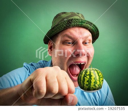 Bizarre man preparing to eat watermelon Bizarre man preparing to eat watermelon 19207535
